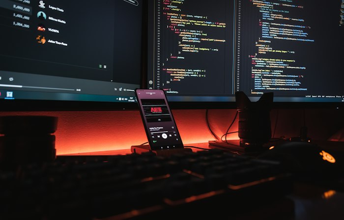 Developer workspace with code on screens